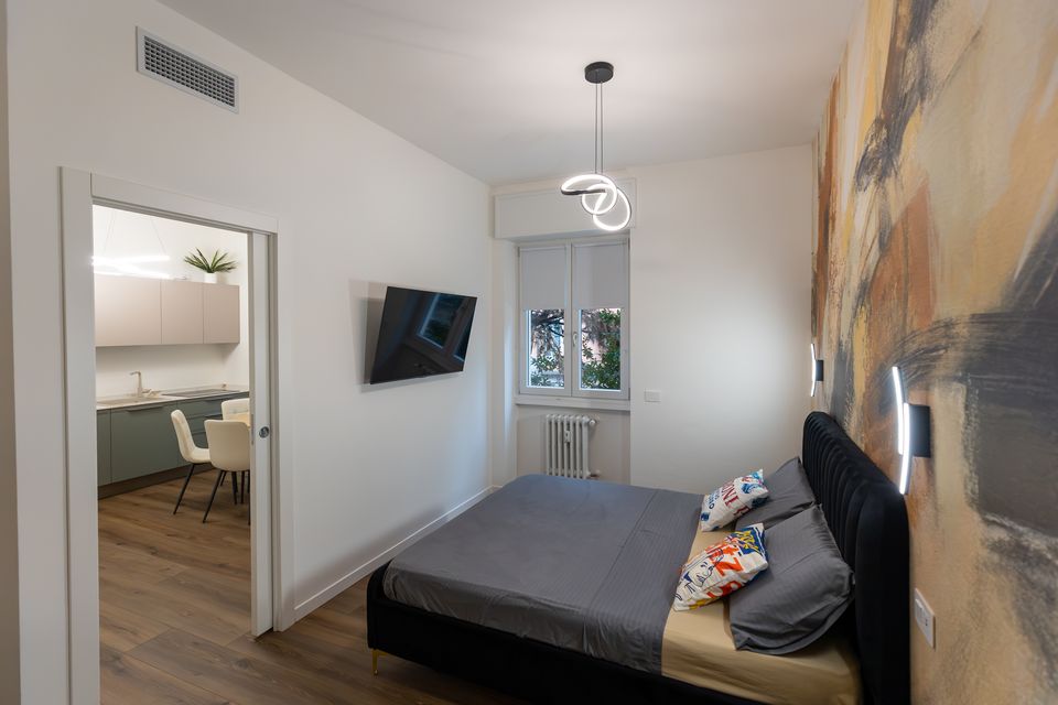 Camera dell'appartamento Bulldog Home Bergamo con, oltre la porta, la cucina