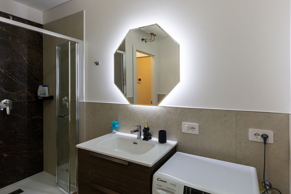 Bagno dell'appartamento Bulldog Home Bergamo con specchio illuminato e doccia