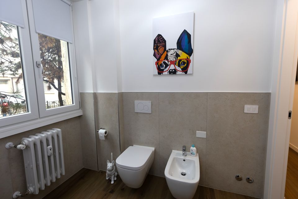Bagno luminoso dell'appartamento Bulldog Home Bergamo con finestra e quadro con bulldog