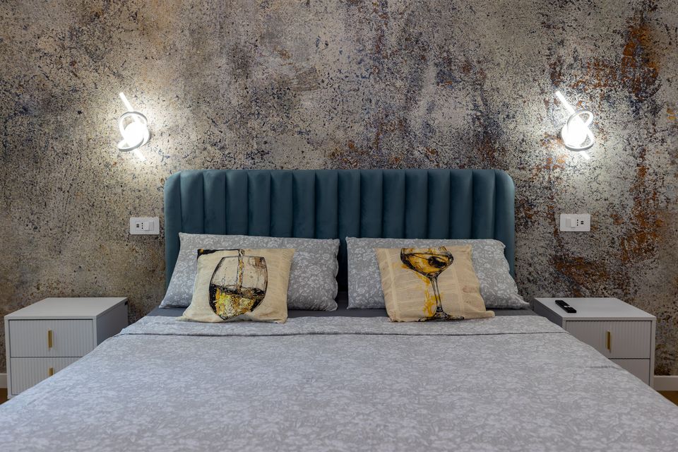 Camera matrimoniale dell'appartamento Champagnerie con letto azzurro e parete effetto pietra