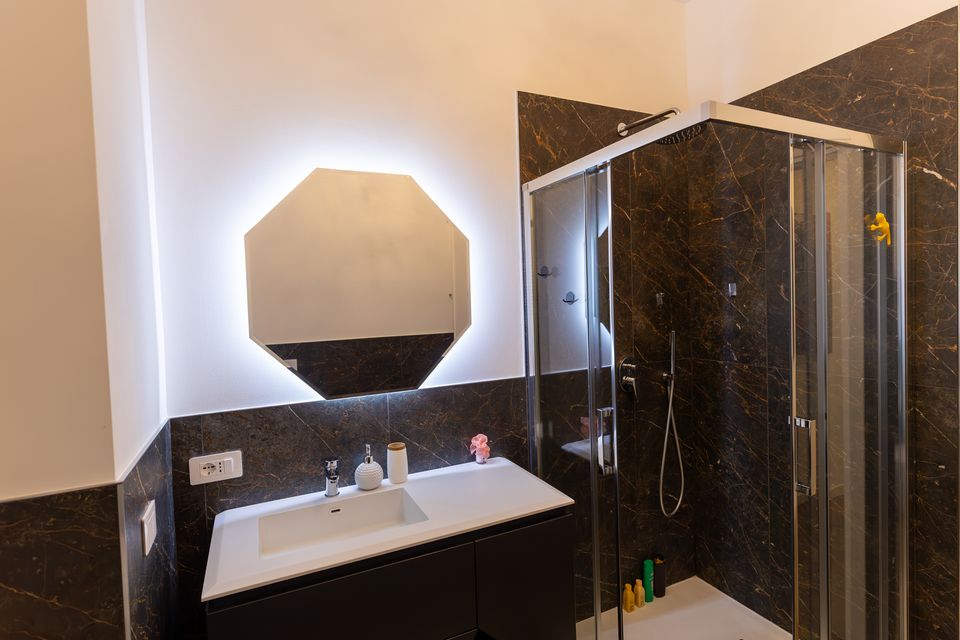 Bagno dell'appartamento Glamour con specchio illuminato e doccia